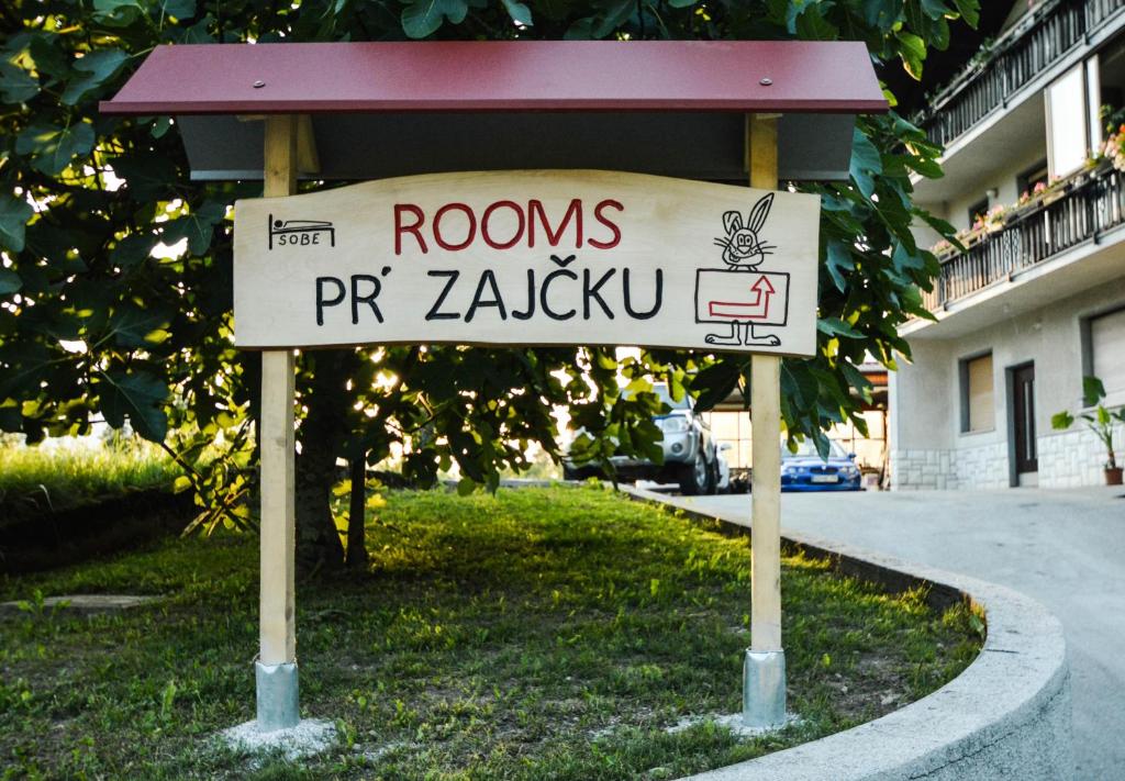 un cartel en el césped frente a un edificio en Rooms pr zajčku en Tolmin