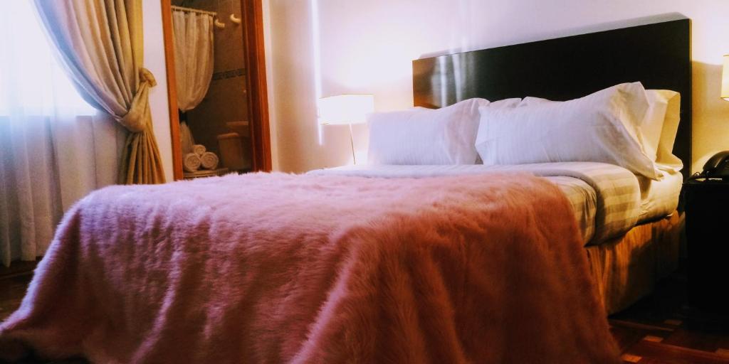 - une chambre avec un grand lit et une couverture rouge dans l'établissement Hotel Casa Gaia, à Bogotá