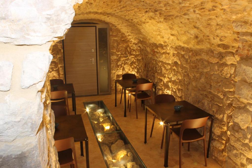 ein Restaurant in einer Höhle mit Tischen und Stühlen in der Unterkunft L'Orologio Bed & Breakfast in Capaccio-Paestum