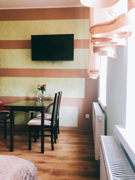 jadalnia ze stołem i telewizorem na ścianie w obiekcie Apartament Przy Deptaku w Drawsku Pomorskim