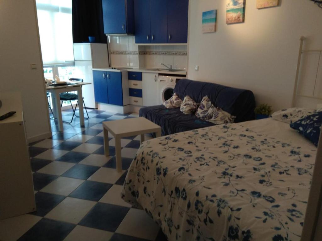 sypialnia z łóżkiem i kanapą oraz kuchnia w obiekcie M3 904 Azul Mediterráneo bonito y confortable estudio w mieście Benalmádena