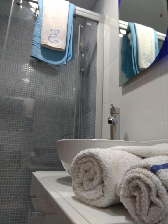 W łazience znajduje się umywalka oraz prysznic z ręcznikami. w obiekcie M3 904 Azul Mediterráneo bonito y confortable estudio w mieście Benalmádena