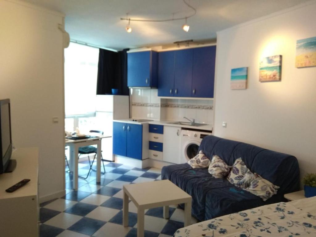 salon z niebieską kanapą i kuchnią w obiekcie M3 904 Azul Mediterráneo bonito y confortable estudio w mieście Benalmádena