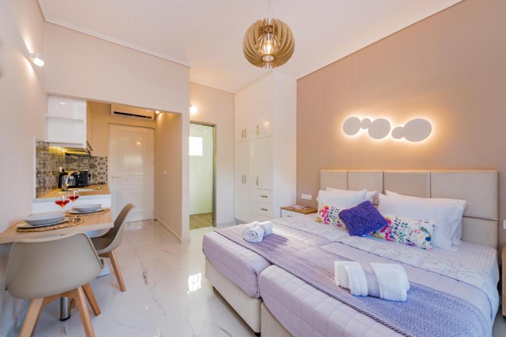 a bedroom with a large bed and a kitchen at Margaritari Apartments in Zakynthos