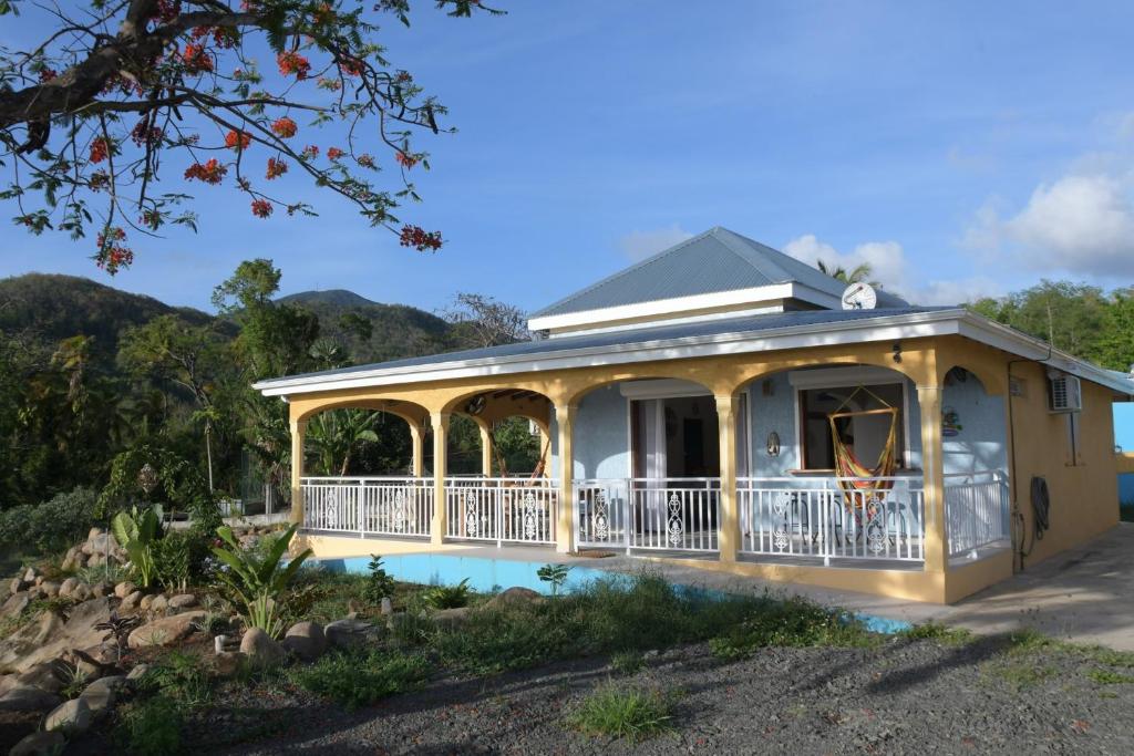 a house with a wrap around porch with a wrap around deck at villa stenella in Bouillante