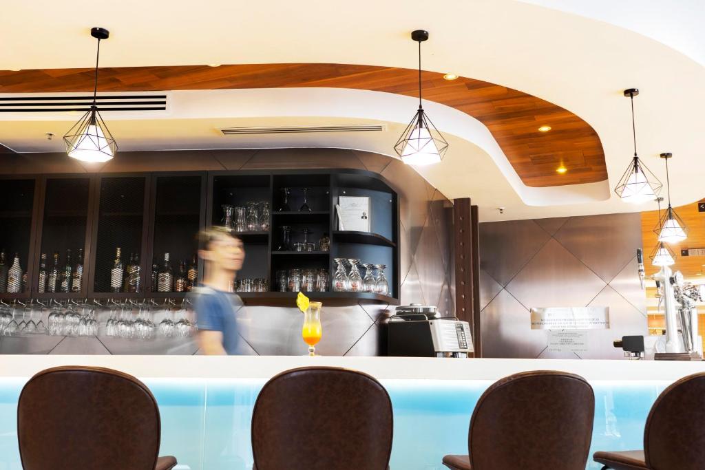 a woman standing behind a bar in a restaurant at Ibis Hong Kong Central & Sheung Wan in Hong Kong