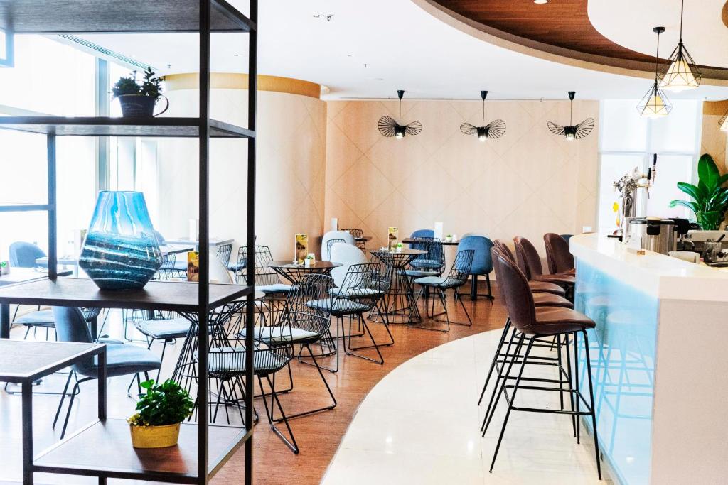 a restaurant with tables and chairs in a room at Ibis Hong Kong Central & Sheung Wan in Hong Kong