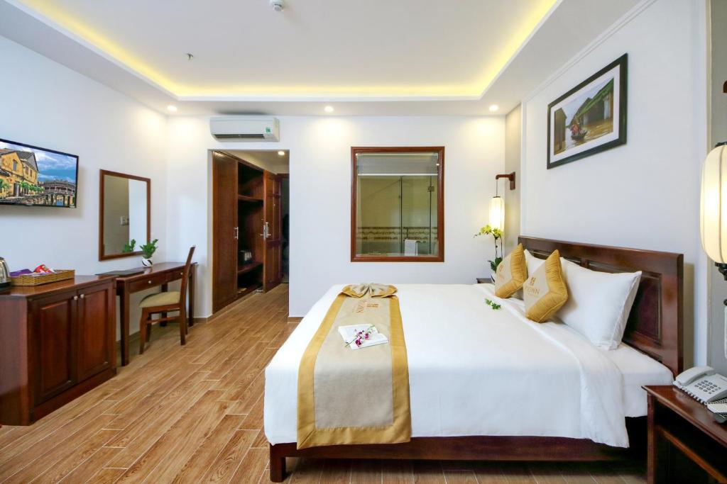 Postel nebo postele na pokoji v ubytování Uptown Hoi An Hotel & Spa