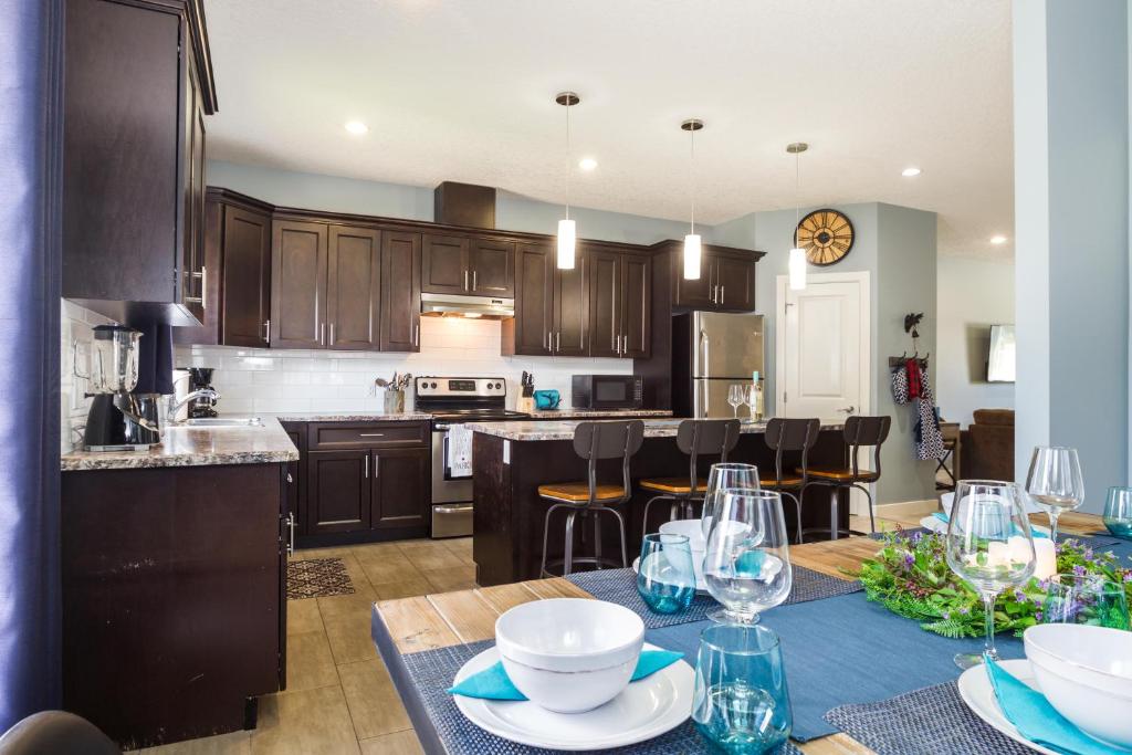 uma cozinha com armários de madeira e uma mesa com pratos em Mountain House em Edmonton