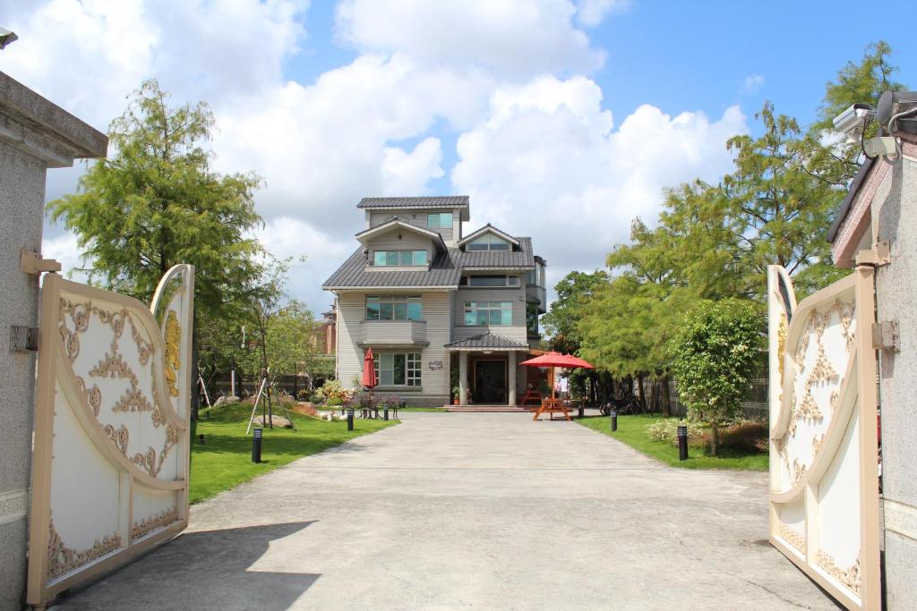 Yilan Pine Villa Homestay في ليودونغ: منزل به بوابة تؤدي إلى ممر