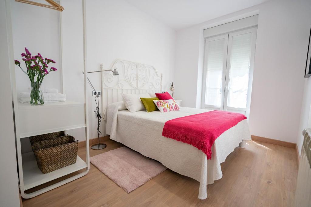 1 dormitorio blanco con 1 cama con manta roja en La Fontina de Luarca en Luarca