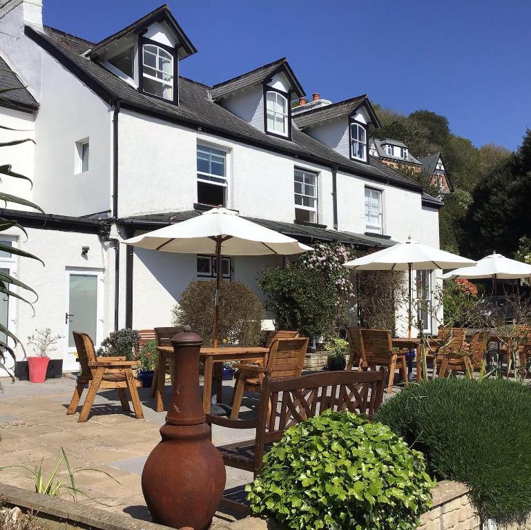 una casa con mesa, sillas y sombrilla en Epchris House, en Ilfracombe