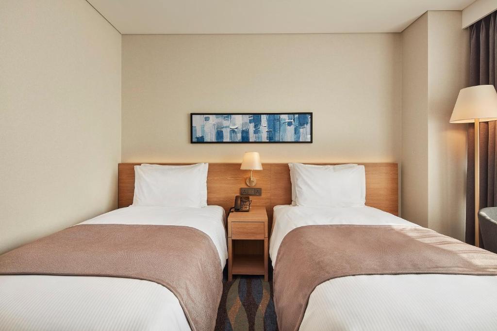 Postel nebo postele na pokoji v ubytování Ramada Encore by Wyndham Gimpo Han River Hotel