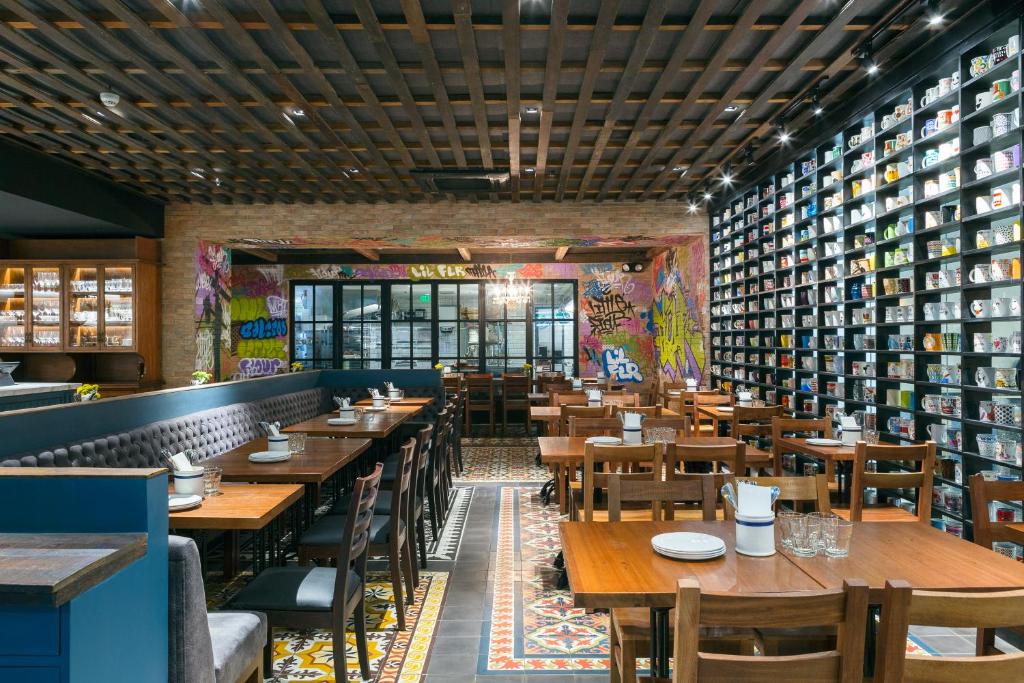 a restaurant with wooden tables and chairs and books at The Sphere Serviced Residences Managed by HII in Manila