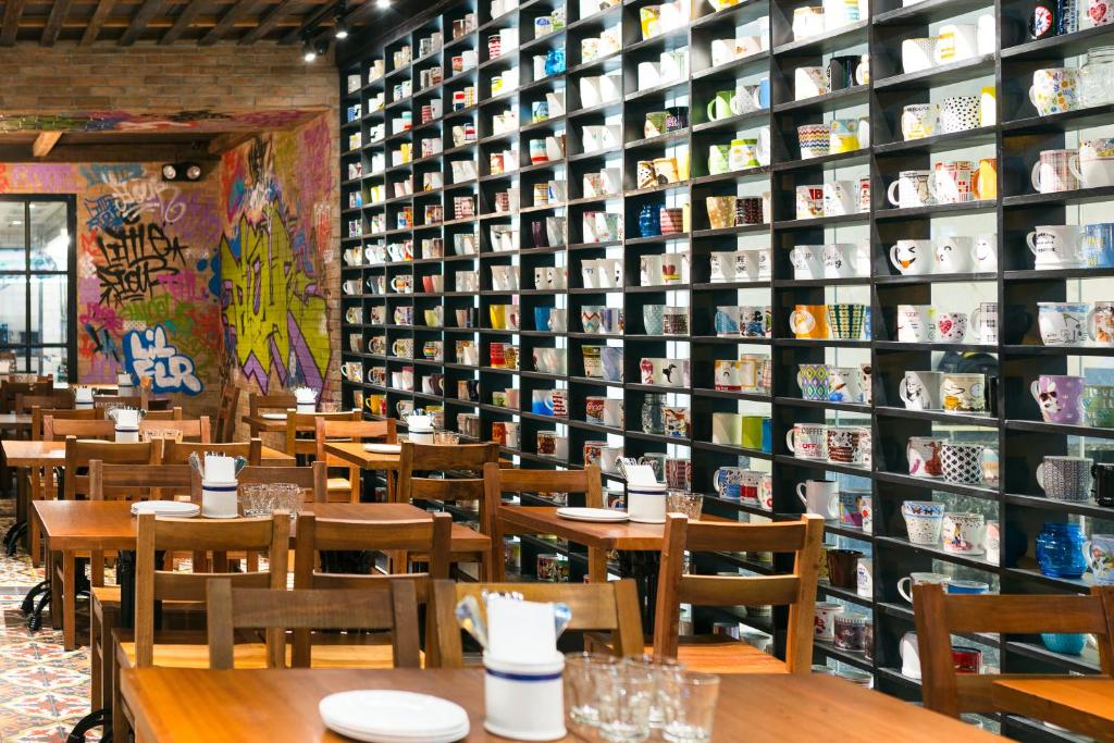 a restaurant with tables and a wall of books at The Sphere Serviced Residences Managed by HII in Manila