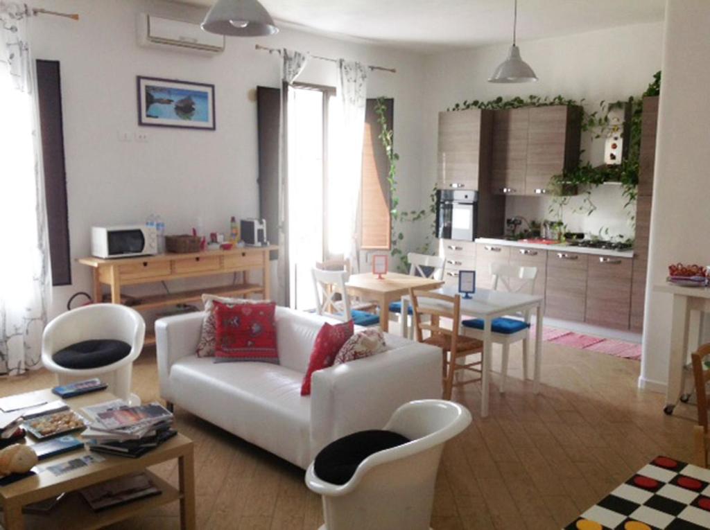 sala de estar con sofá blanco y cocina en Kabed en Porto Empedocle