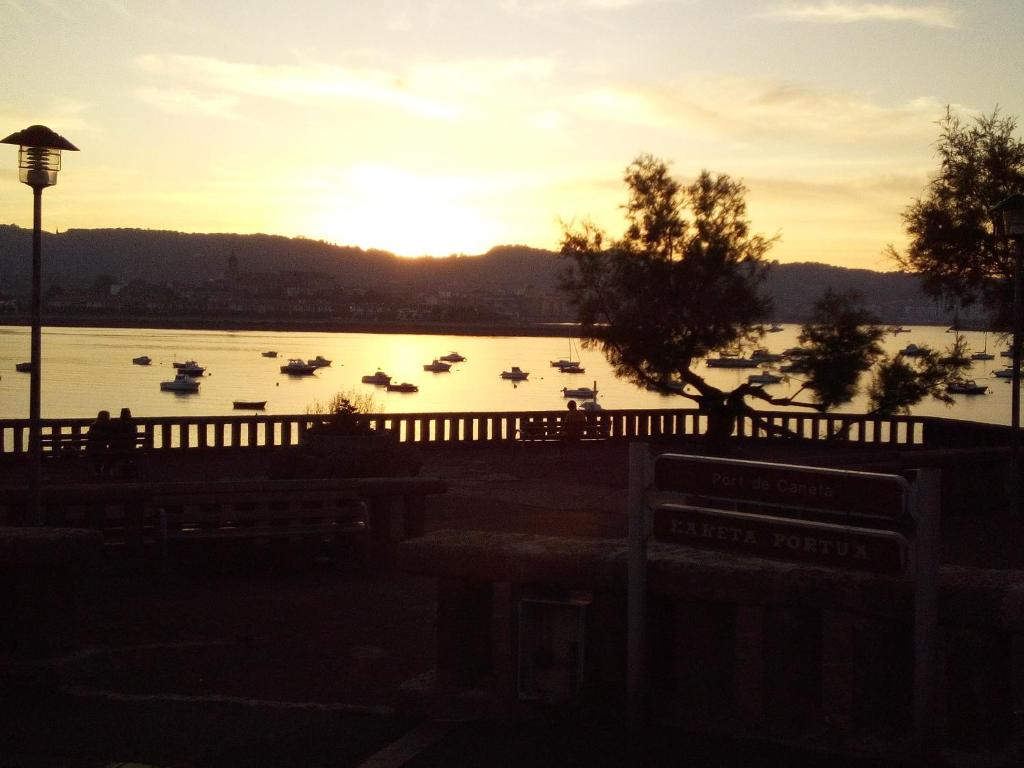 einen Sonnenuntergang über einem See mit Booten im Wasser in der Unterkunft Ático en Port Kaneta in Hendaye