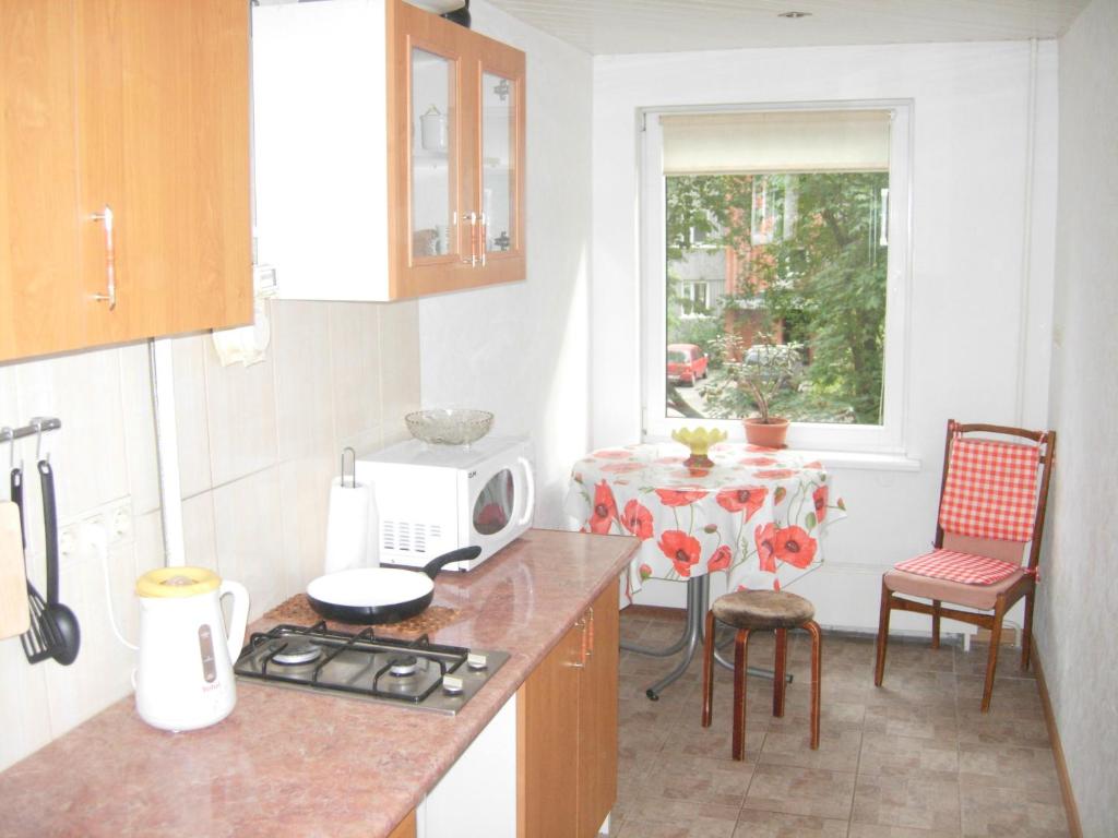 a kitchen with a counter and a table and a window at Happy Land in Jūrmala