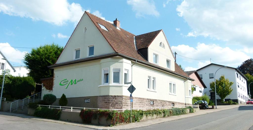 een wit huis met een bruin dak op een straat bij Casa Maria App. Maria in Sankt Wendel