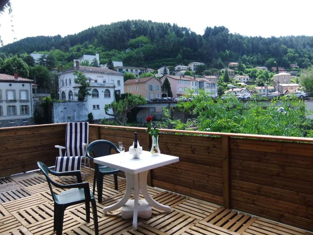 une table et des chaises sur un balcon avec vue dans l'établissement ESCALE, à Vals-les-Bains