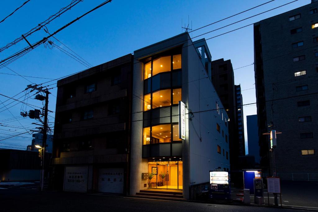 a building with lights in the windows of it at RIVER SUITES HIROSHIMA in Hiroshima