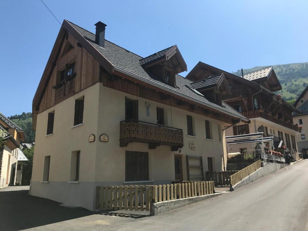 um edifício com um telhado de madeira numa rua em Charmant Appartement Centre Ville Valloire em Valloire