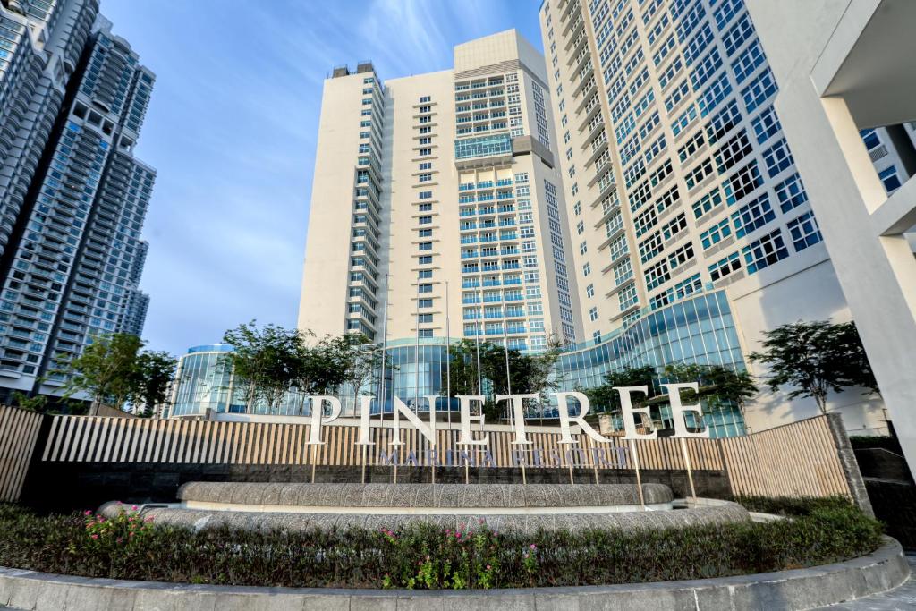 un panneau devant un bâtiment avec de grands bâtiments dans l'établissement Pinetree Marina Resort, à Nusajaya