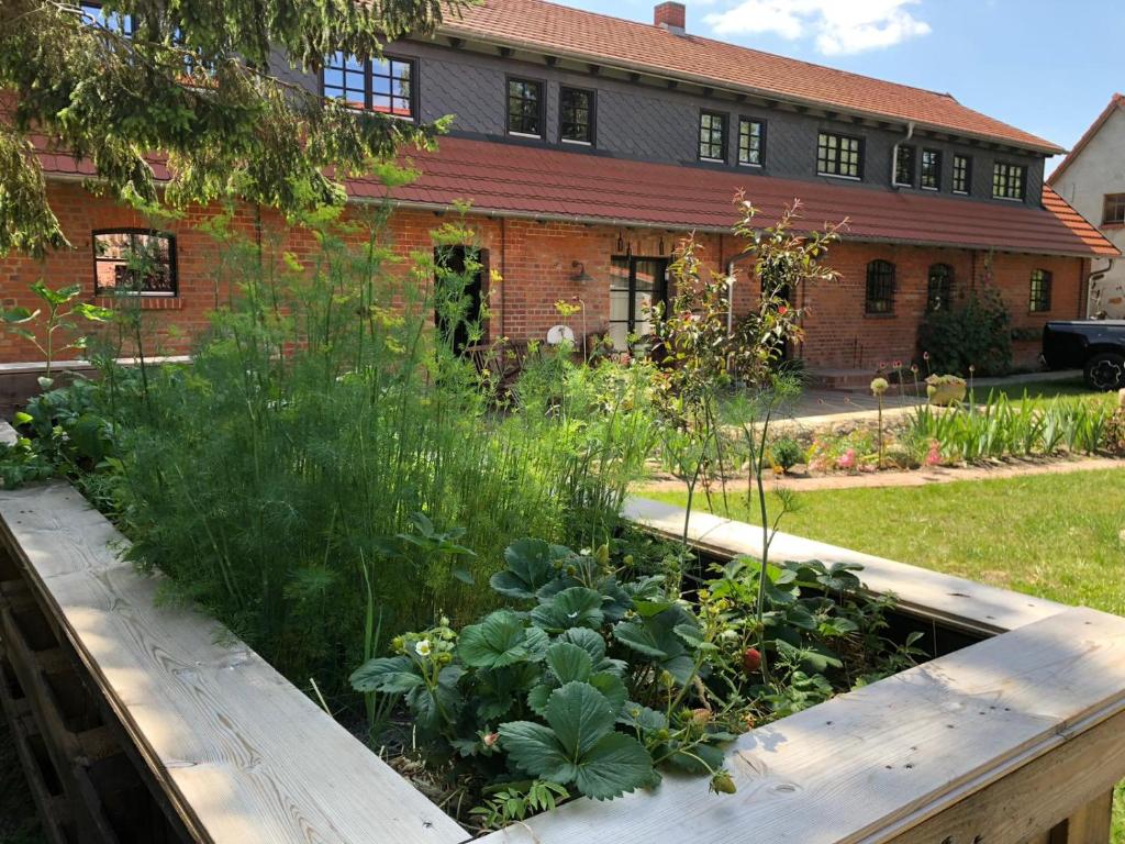 einen Garten vor einem Backsteinhaus in der Unterkunft Appartement Alte Schmiede in Lübbenow