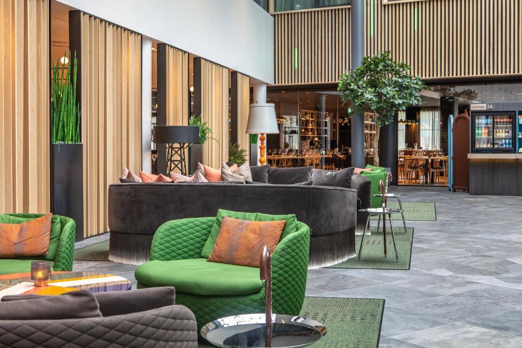 a lobby with couches and chairs in a building at Quality Airport Hotel Gardermoen in Gardermoen