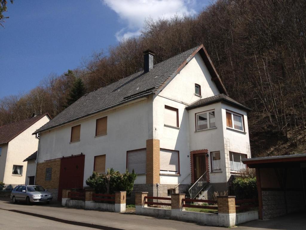 una casa blanca con un coche aparcado delante de ella en Haus an der Diemel, en Diemelsee