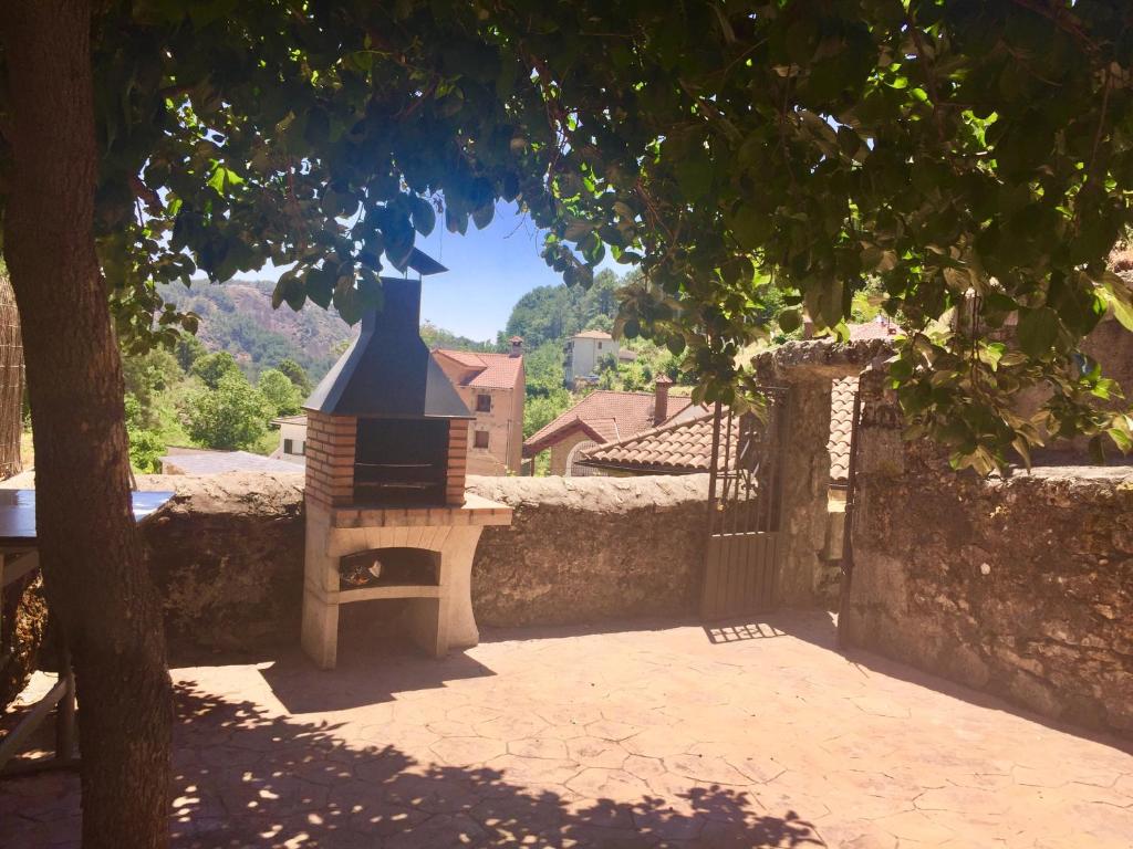 una casa de pájaros sentada en un banco bajo un árbol en Casa San Marcos, en El Hornillo