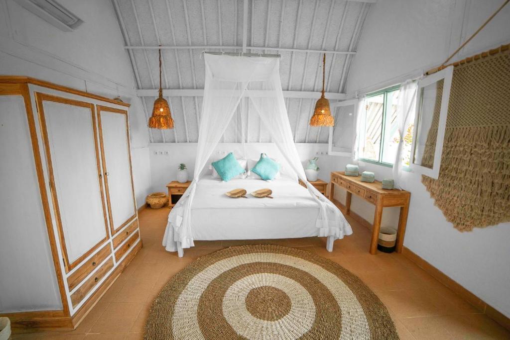 1 dormitorio con 1 cama blanca con dosel en 7SEAS Cottages en Gili Air