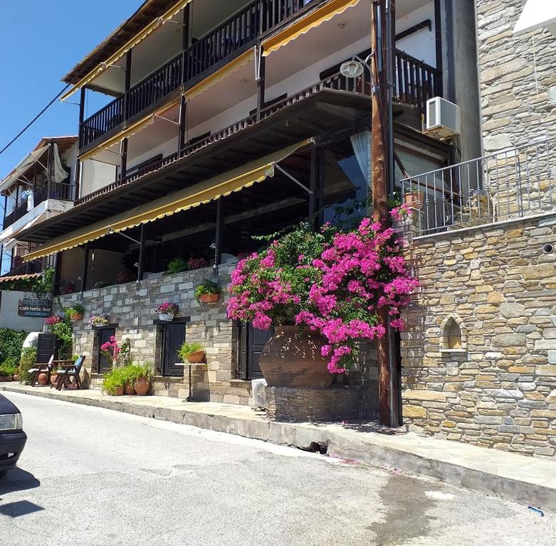 a building with flowers on the side of it at Maistrali Hotel in Afissos