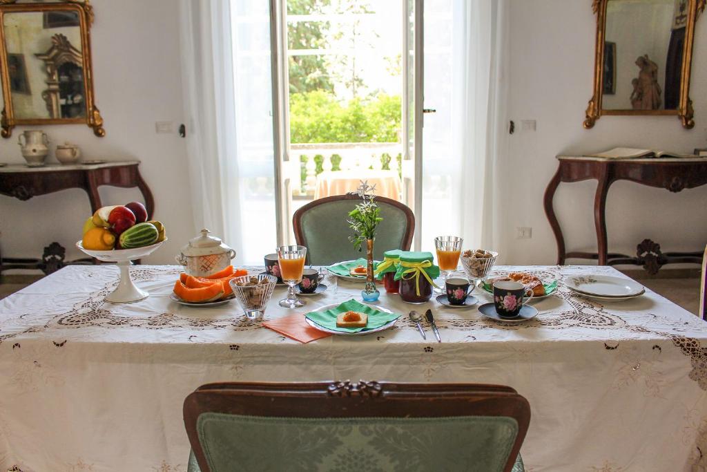 einen Tisch mit Essen und Obst darüber in der Unterkunft B&B Palazzo Sambiasi in Lecce
