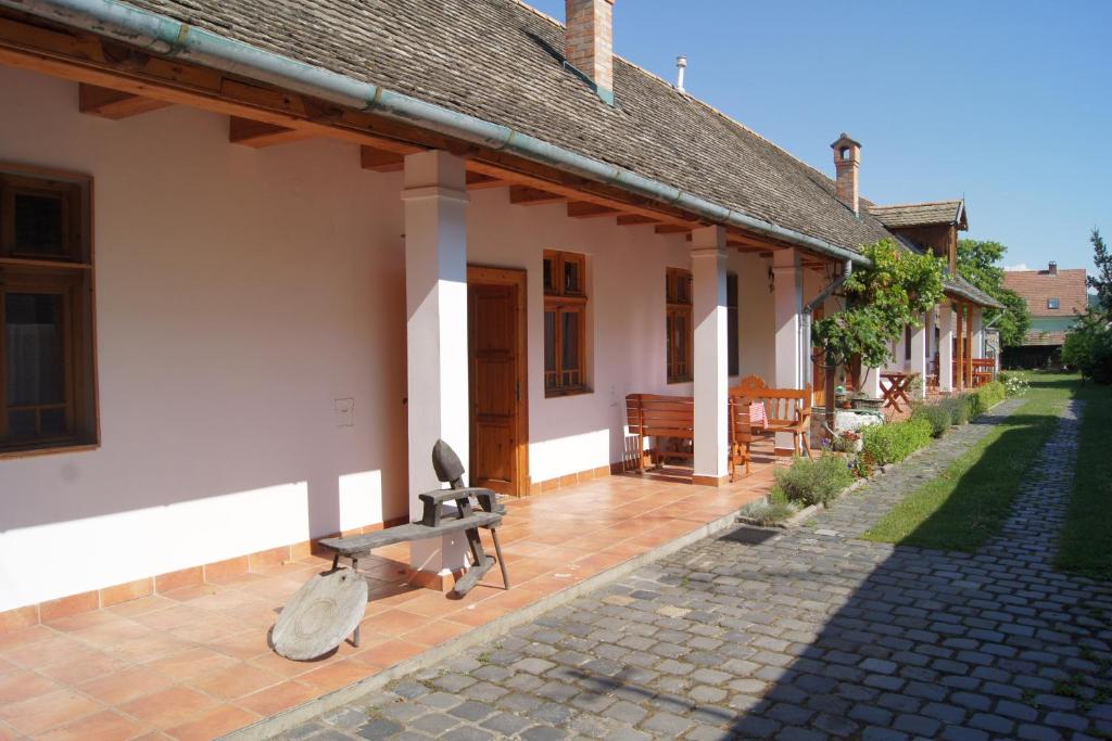 a house with a bench in front of it at Rácz Fogadó in Kisoroszi