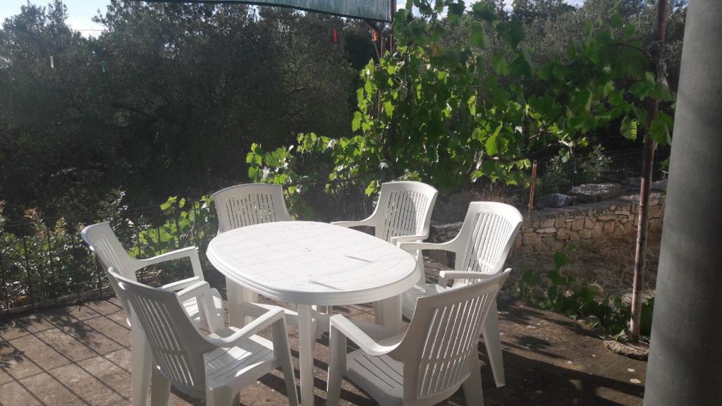 un grupo de sillas blancas alrededor de una mesa blanca en Charming house Tonći, en Lovište