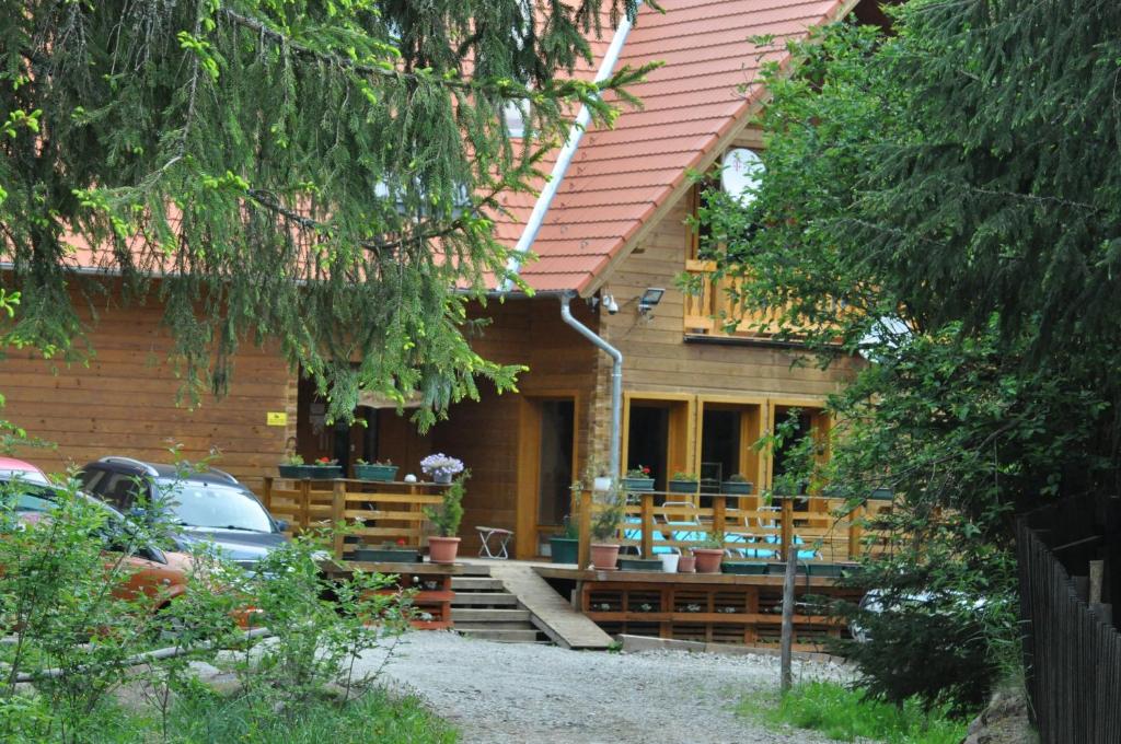 een huis met een terras en een auto geparkeerd aan de voorkant bij Mofetta Panzió in Sîntimbru-Băi