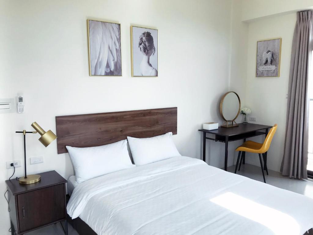 a bedroom with a large white bed and a desk at The Corner 10 in Rende