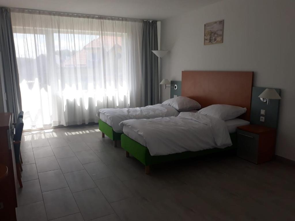 1 Schlafzimmer mit 2 Betten und einem großen Fenster in der Unterkunft LEMA Pokoje Gościnne in Skrzeszewo