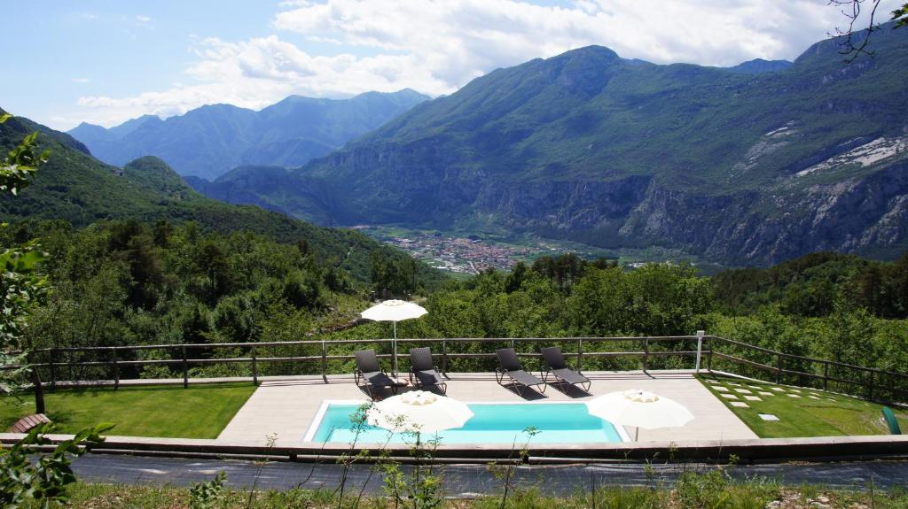 una piscina con sillas y sombrillas y vistas a las montañas en Maso Salim Relax Apartments, en Drena