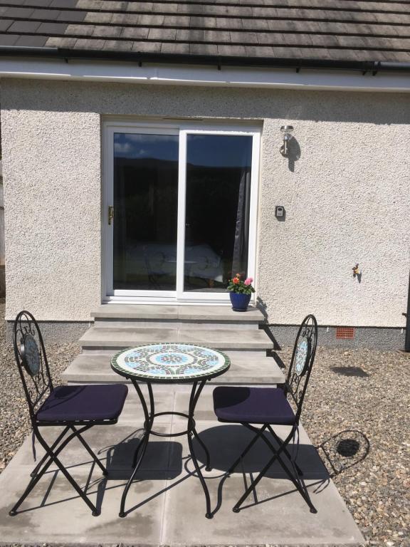 d'une terrasse avec une table, deux chaises et une table. dans l'établissement The Willows, à Dalchreichart