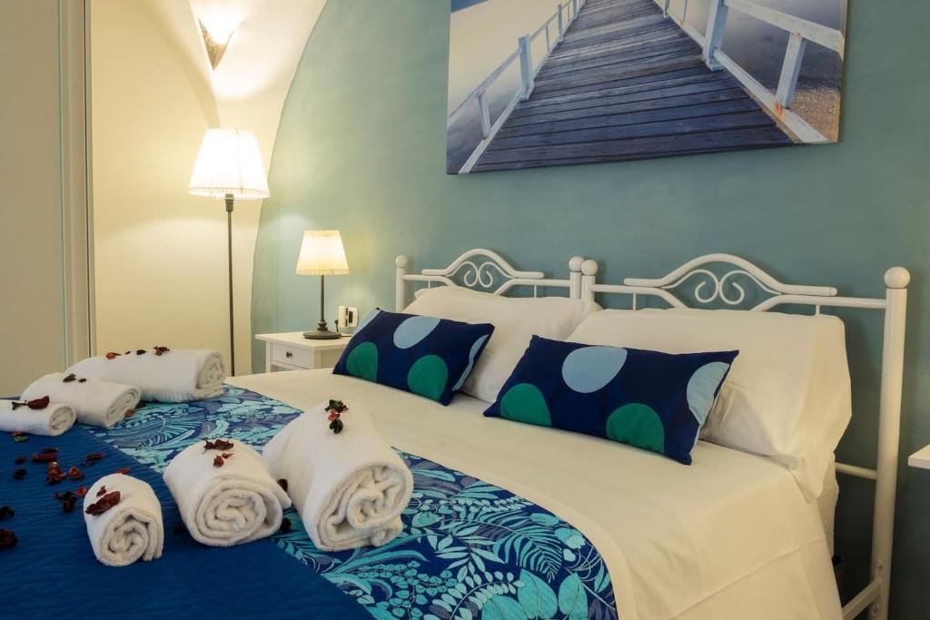 1 dormitorio con 1 cama con toallas en Little House Napoli, en Nápoles