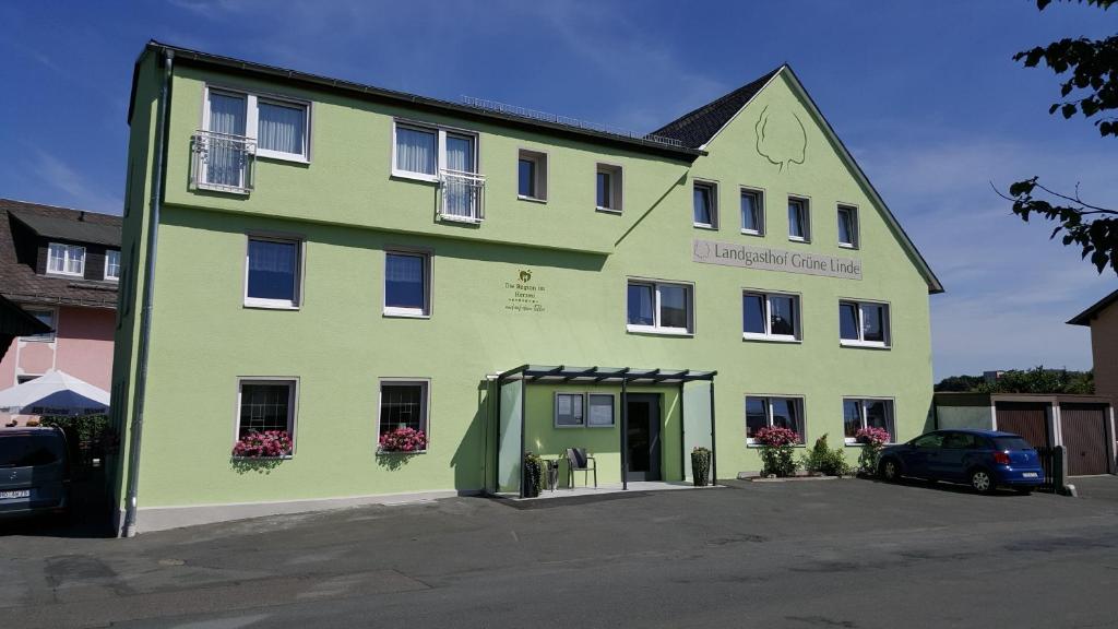 un bâtiment vert avec une voiture garée devant lui dans l'établissement Landgasthof Grüne Linde, à Hof