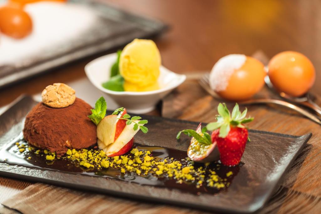 a plate with chocolate cake and strawberries on a table at Jazz Hotel in Olbia