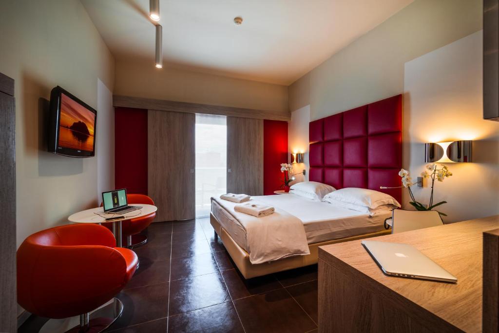 a bedroom with a bed and a desk with a laptop at Jazz Hotel in Olbia