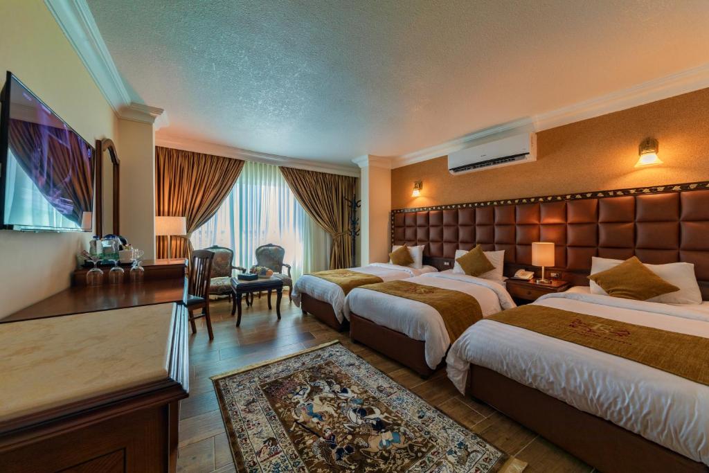 a large hotel room with two beds and a table at Town Season Hotel in Wadi Musa