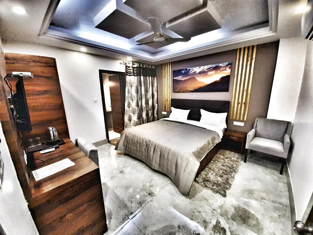 a bedroom with a bed and a chair in it at Hotel Aerocity Purple Orchid in New Delhi