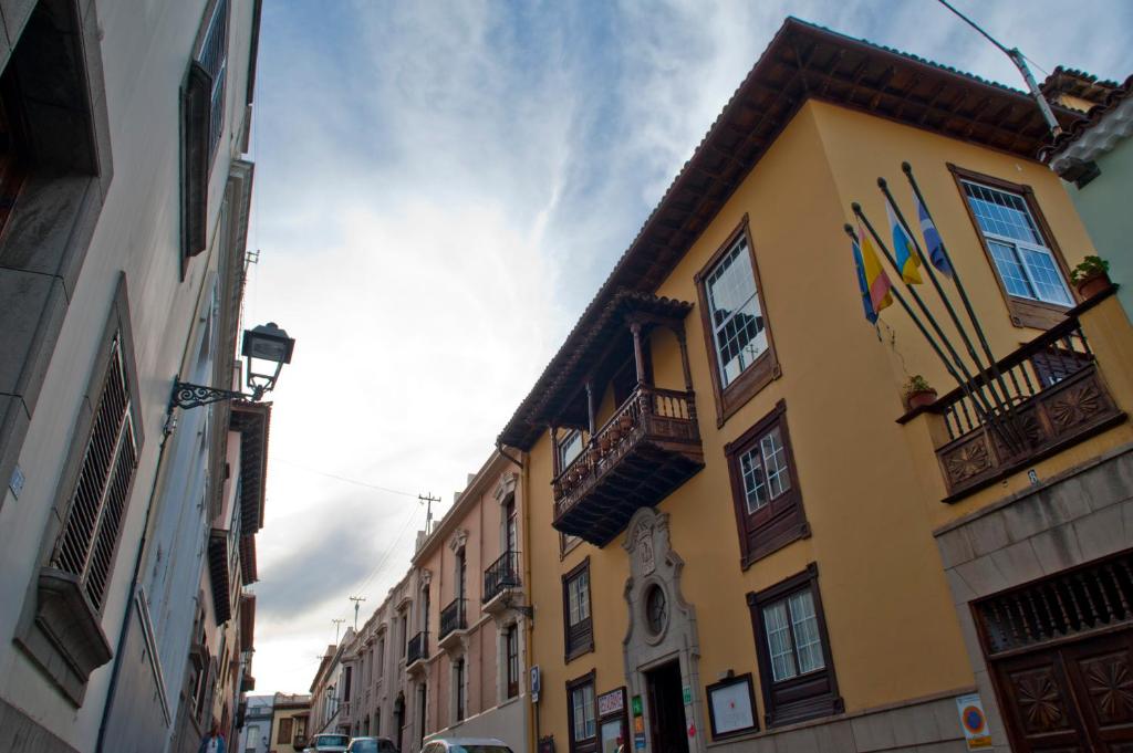 een geel gebouw met vlaggen aan de zijkant bij Hotel Rural Victoria in La Orotava