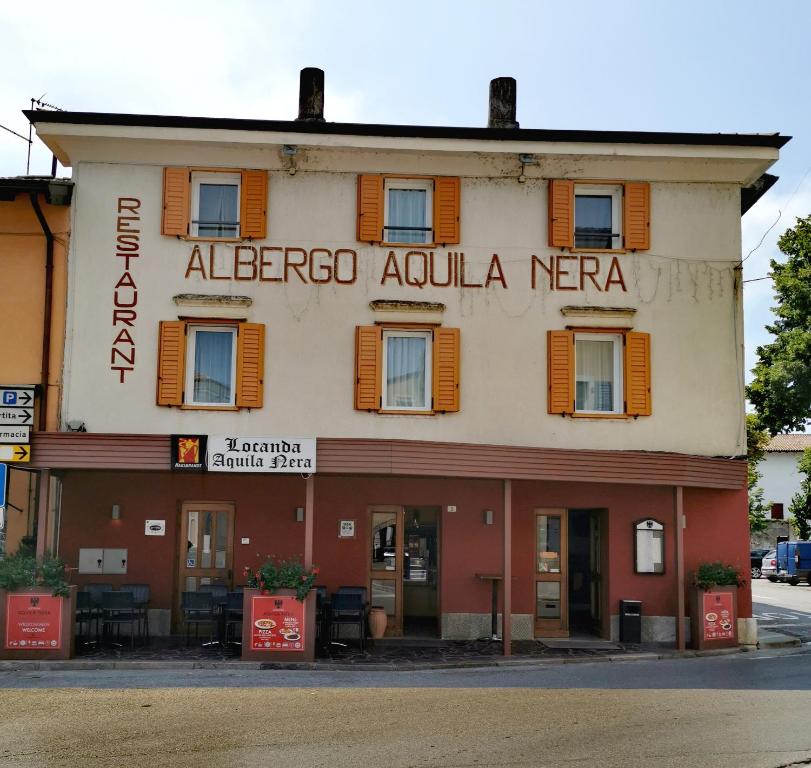 a building with a sign that reads albereco acula neera at Locanda Aquila Nera in Aquiléia