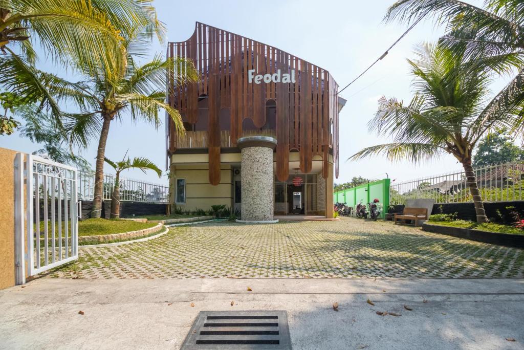 un hotel con palme di fronte a un edificio di RedDoorz near UMY Yogyakarta 3 a Yogyakarta